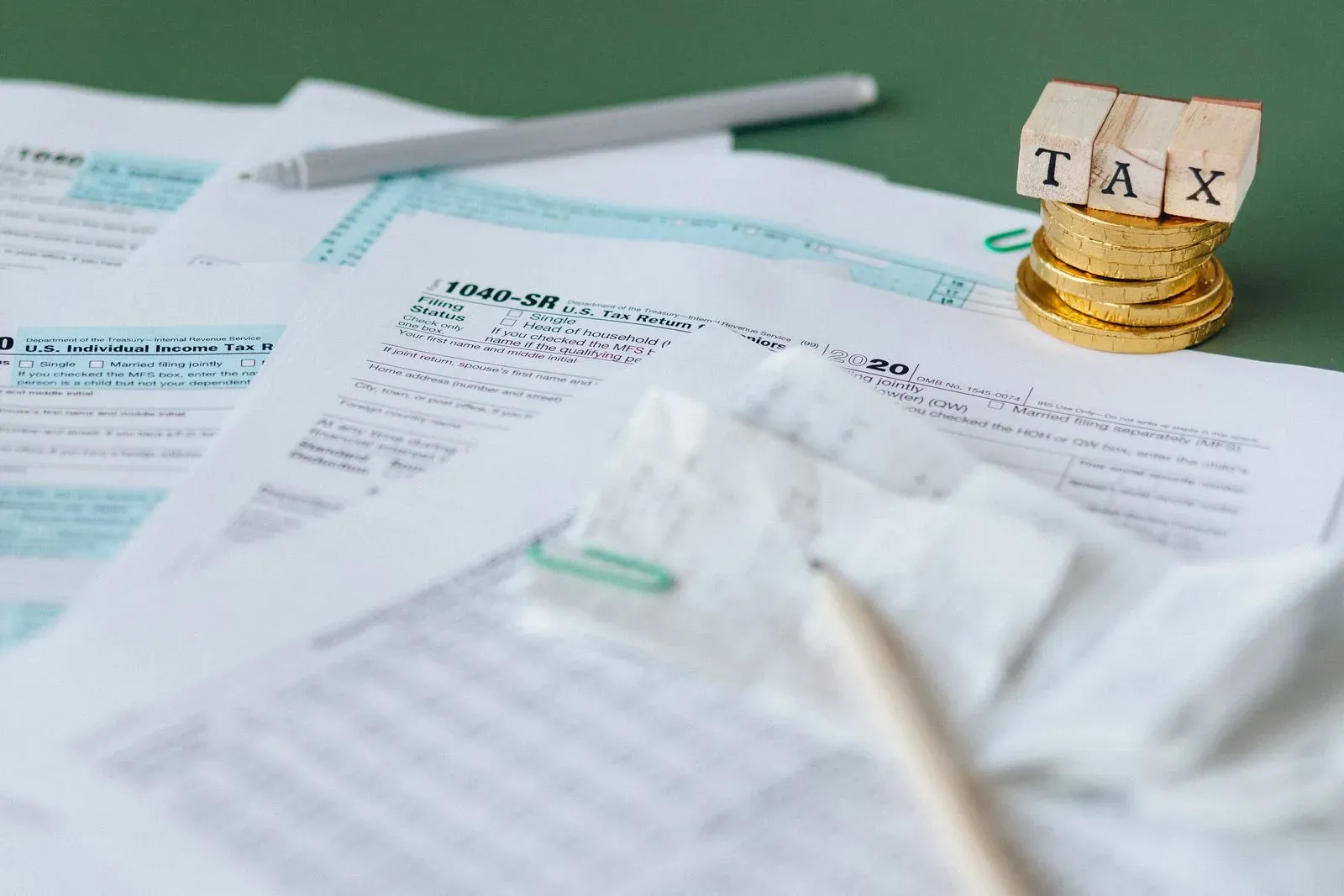 Documentos de la declaración de impuestos junto a criptomonedas sobre la mesa de un despacho de abogados penalistas